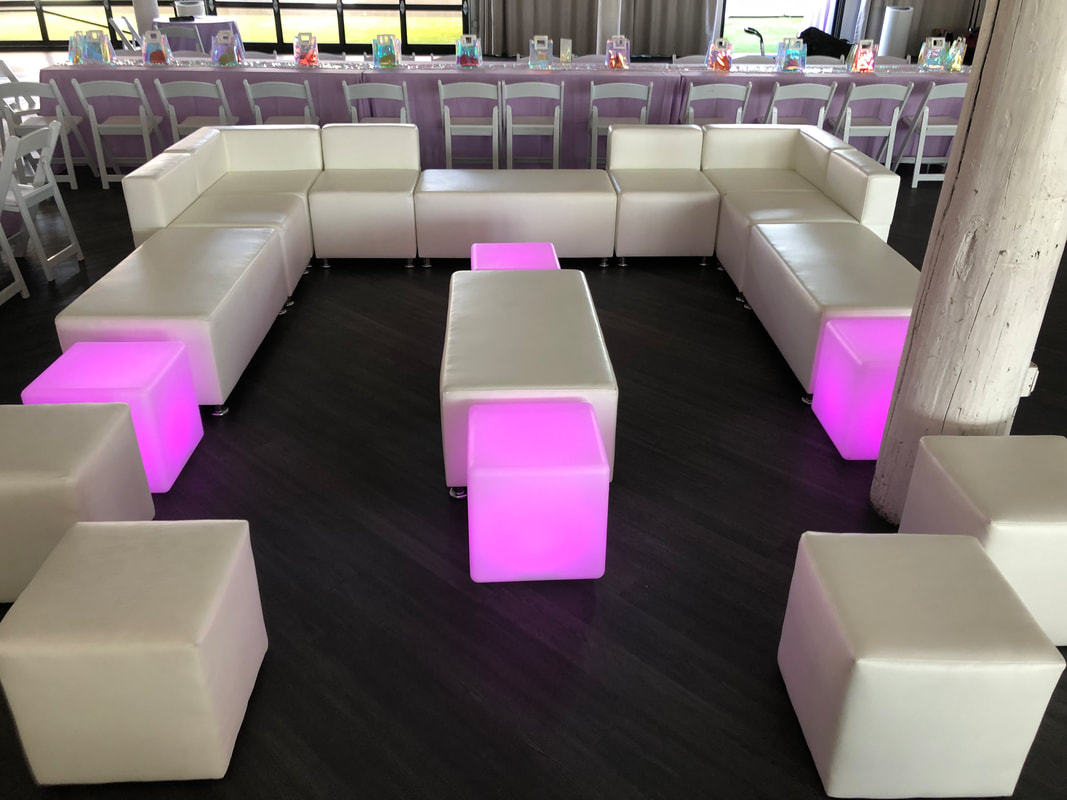 U-shaped white modular lounge with pink LED glow cubes at a reception