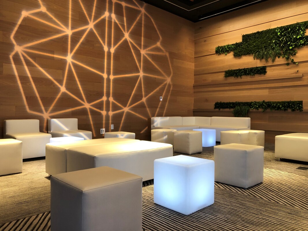White lounge seating and illuminated cubes in a warm wood-paneled venue